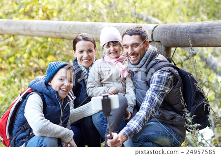 happy family with smartphone selfie stick in woods 24957585