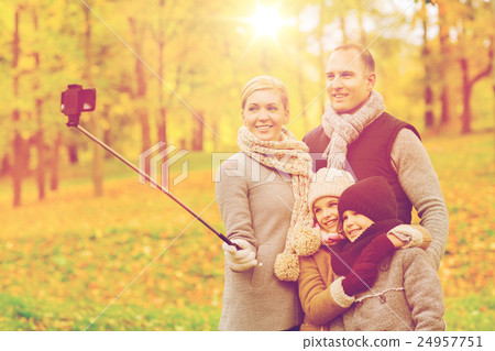 happy family with smartphone and monopod in park 24957751