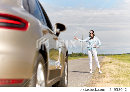 woman hitchhiking and stopping car at countryside 24958042