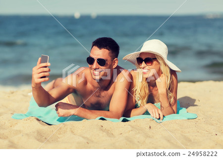 happy couple in swimwear walking on summer beach happy couple in swimwear walking on summer beach 24958222