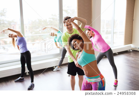 group of smiling people stretching in gym 24958308