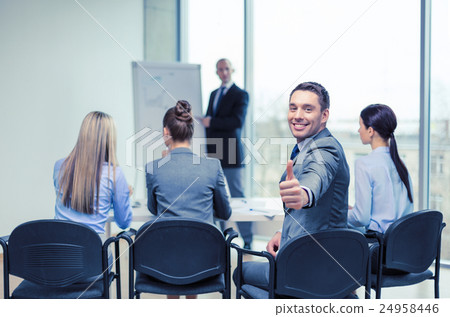 businessman with team showing thumbs up in office businessman with team showing thumbs up in office 24958446