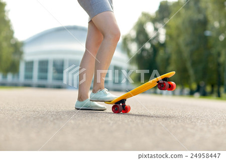 close up of female feet riding short skateboard close up of female feet riding short skateboard 24958447