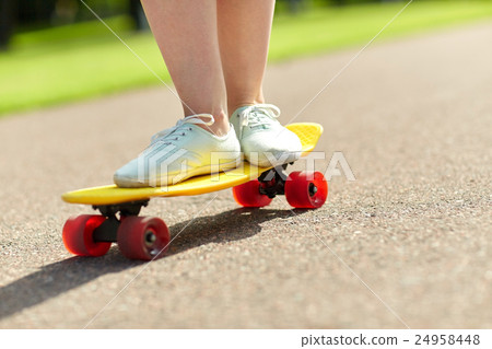 close up of female feet riding short skateboard close up of female feet riding short skateboard 24958448