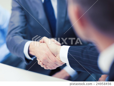 two businessmen shaking hands in office two businessmen shaking hands in office 24958456