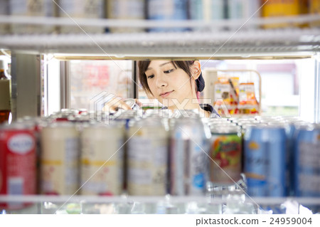 A young lady guest who takes out drinks from the refrigerator at the drink corner A young lady guest who takes out drinks from the refrigerator at the drink corner 24959004