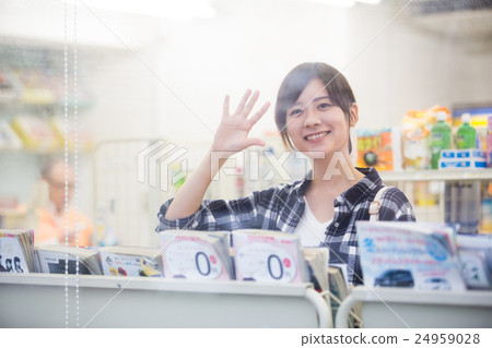 揮動手的婦女,當瀏覽在便利商店時 揮動手的婦女,當瀏覽在便利商店時 24959028