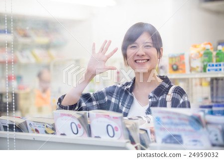 一個女人在便利店瀏覽時向朋友揮手 一個女人在便利店瀏覽時向朋友揮手 24959032