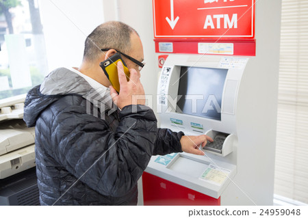 通過電話指導操作ATM的中老年男性 24959048