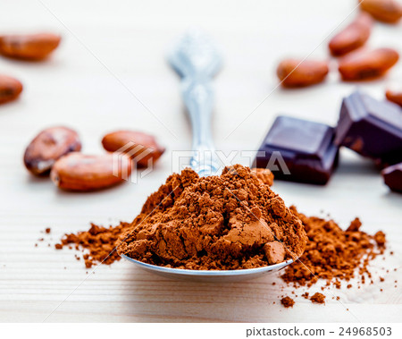 Brown chocolate powder in spoon. Brown chocolate powder in spoon. 24968503