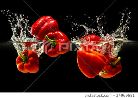 Group of bell pepper falling in water on black 24969681