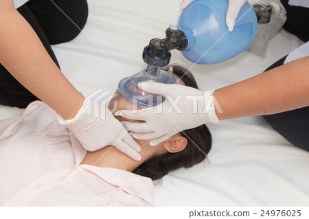 Medical team is giving first aid to young woman 24976025