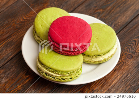 Four traditional french colorful macarons on plate 24976610