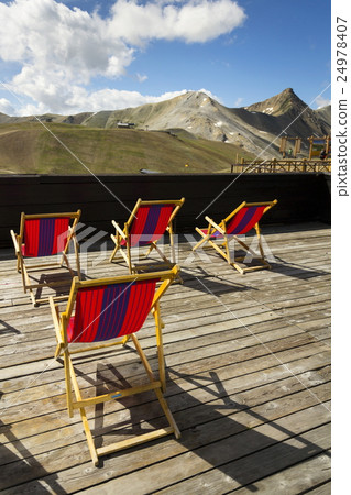 Deckchairs on terrace with Italian Alps mountains 24978407