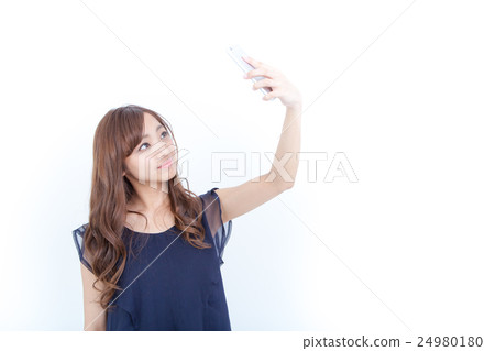 A young woman taking a picture on her own smartphone A young woman taking a picture on her own smartphone 24980180