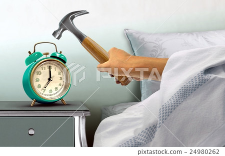 Hand hitting alarm clock with hammer 24980262