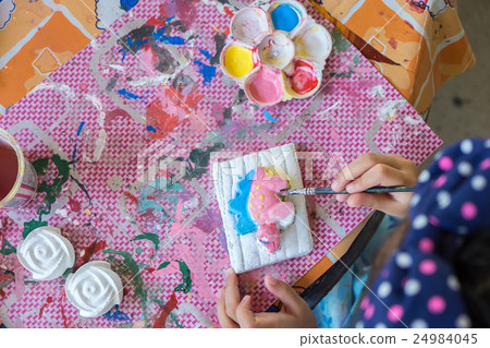 Little hands of kid painting on the plaster statue Little hands of kid painting on the plaster statue 24984045
