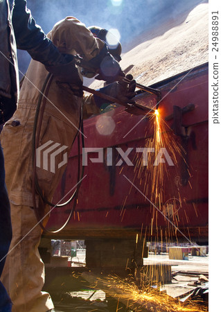 Man welding wearing protective clothes and equipme 24988891