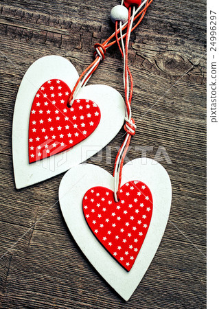 two decorative red and white heart on a wooden 24996297