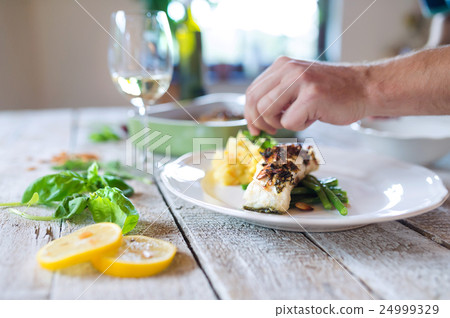 Unrecognizable man serving zander fish fillets on Unrecognizable man serving zander fish fillets on 24999329