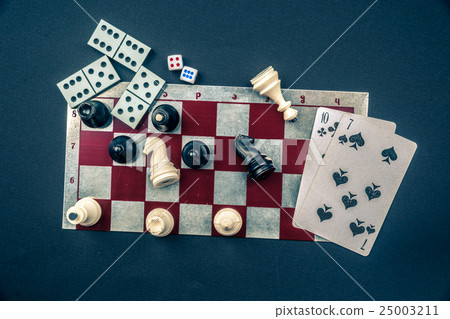 Various board games and figurines over checkers 25003211