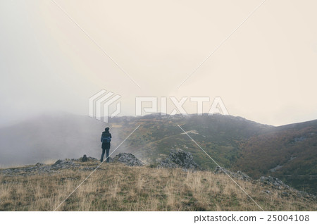 Woman hiking on a cloudy autumn day 25004108