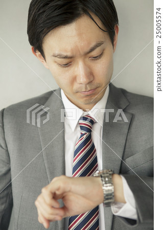 A businessman looking at a watch 25005574