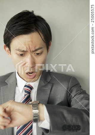 A businessman surprised to see a watch A businessman surprised to see a watch 25005575