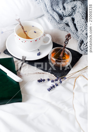 tray with honey and a cup of hot tea in the bed tray with honey and a cup of hot tea in the bed 25008338