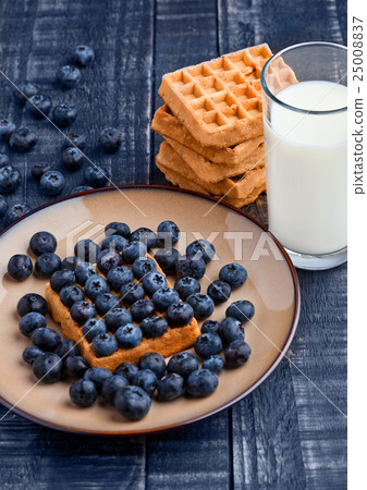 Blueberries and waffles on plate with milk glass 25008837