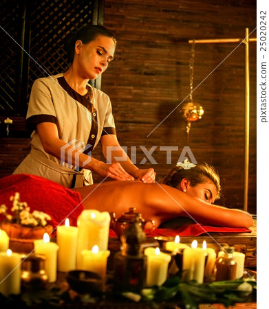 Woman lying on luxary wooden massage spa bed. 25020242
