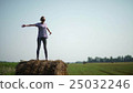Pretty girl is standing on haystacks 25032246