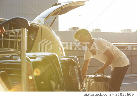 Male loaded with luggage in car at airport parking lot Male loaded with luggage in car at airport parking lot 25033609