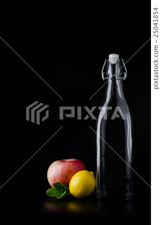 Empty glass bottle, apple and lemon  25041854