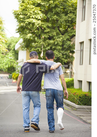 friend helping brothers or patient  to walk  25047370