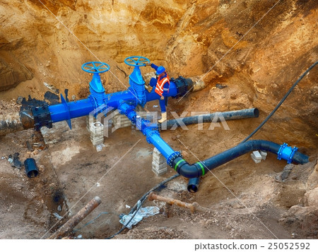 Worker underground at gate valve on drink water Worker underground at gate valve on drink water 25052592