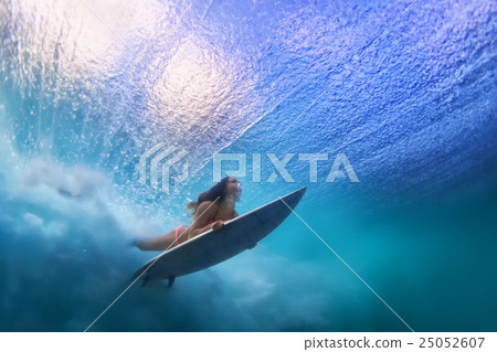 Surfer girl diving under water with surf board Surfer girl diving under water with surf board 25052607
