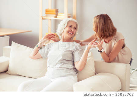 Overjoyed smiling woman resting at home with her Overjoyed smiling woman resting at home with her 25053702