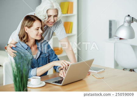 Positive woman using laptop Positive woman using laptop 25059009