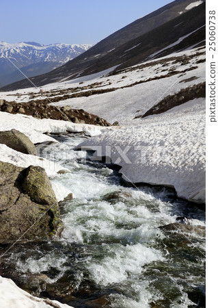 Mountain river with snow bridges in spring sun day 25060738