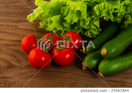 Cucumber and cherry tomato on wooden background 25067864