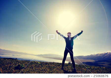 young woman open arms on sunrise mountain peak 25068676
