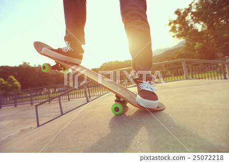 young skateboarder legs skateboarding at skatepark 25072218