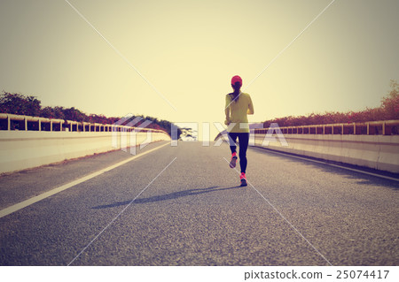 young woman runner running on city bridge road 25074417