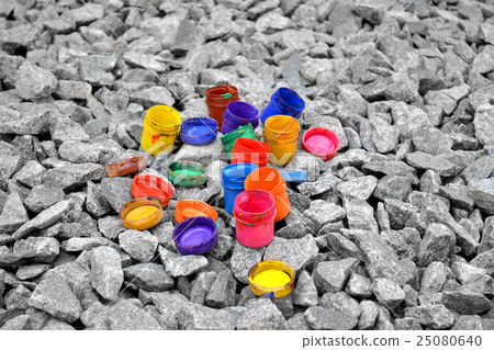 colored small paint cans lie on a gray pebble colored small paint cans lie on a gray pebble 25080640