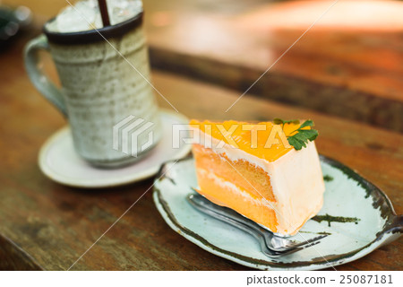 orange cake with ice coffee on wood table 25087181