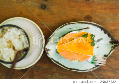 orange cake with ice coffee on wood table 25087182