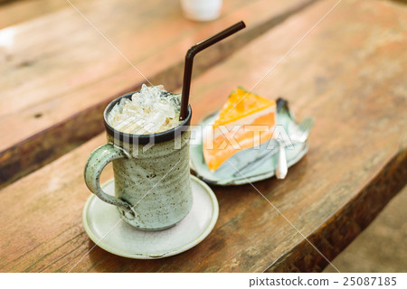 orange cake with ice coffee on wood table 25087185
