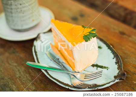 orange cake with ice coffee on wood table 25087186