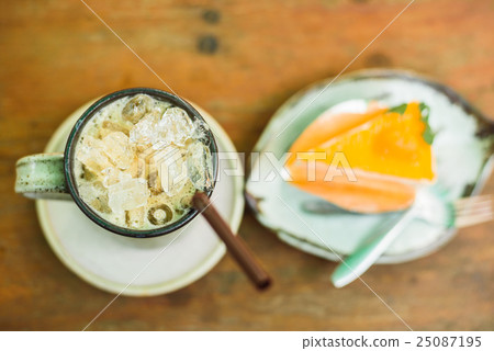 orange cake with ice coffee on wood table 25087195